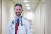 MSK medical oncologist Michael Foote, MD, is seen smiling in a hallway. 