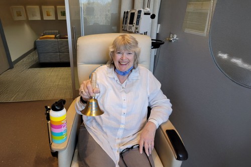 A women sitting in a chair holding a bell